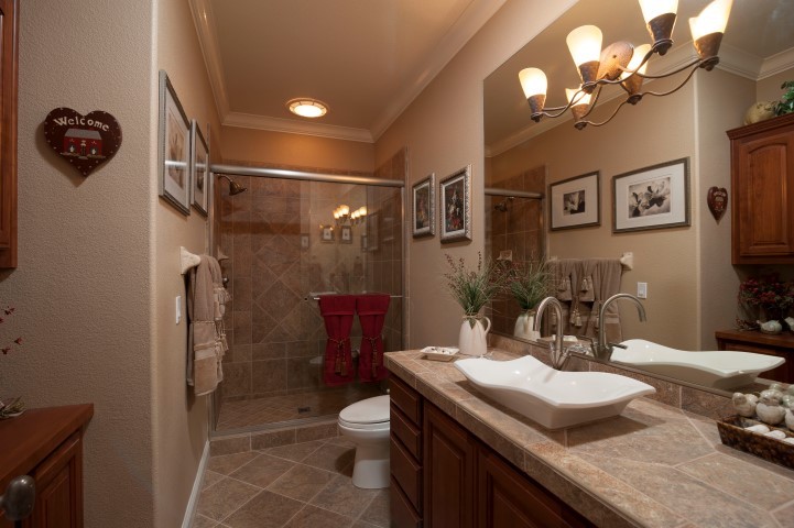 guest bath custom vanities, tile flooring and countertops, plenty of custom cabinet space.